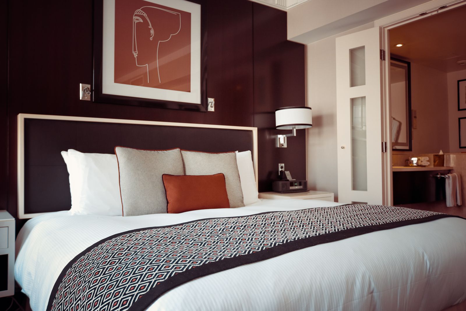 Chambre d'hôtel boutique — lit soigné, linge blanc et lumière douce